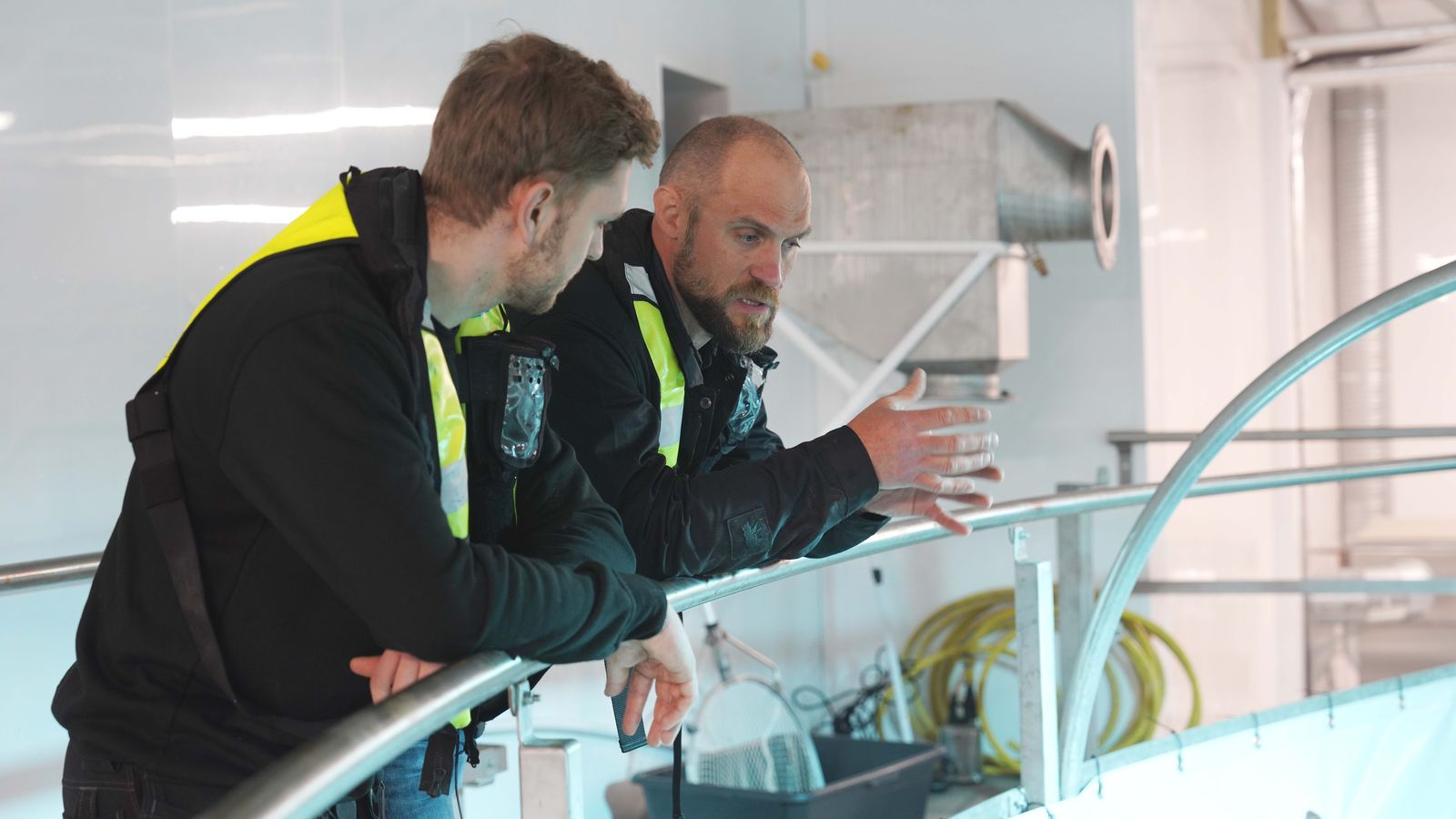 Marius Almenning and Yngve Hjertenes talking at the edge of a tank